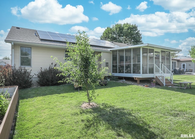 2035 N Gayman Ave, Davenport, IA 52804 - rear view of house featuring a sunroom, a lawn, solar panels, and a shingled roof
