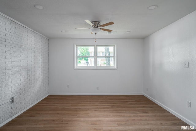 1811 Valley Dr, Davenport, IA 52806 - empty room featuring a ceiling fan, brick wall, and light wood finished floors