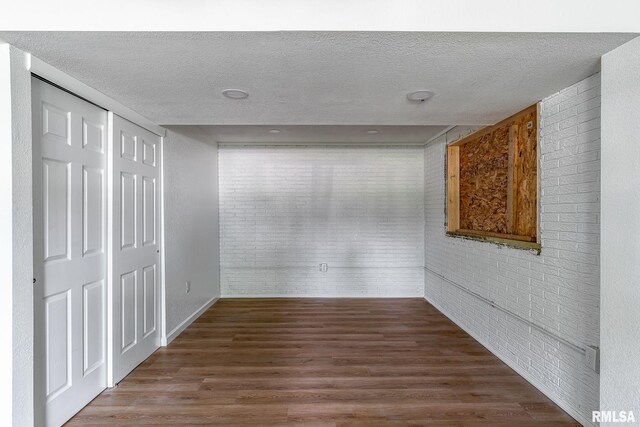 1811 Valley Dr, Davenport, IA 52806 - corridor with dark wood-style flooring, a textured ceiling, and brick wall