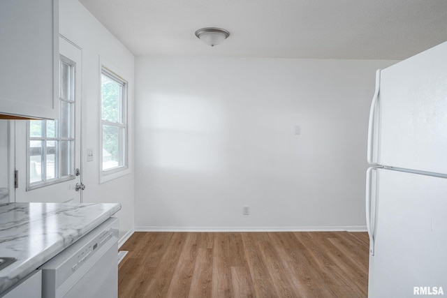 1811 Valley Dr, Davenport, IA 52806 - unfurnished dining area with light wood-style flooring and baseboards
