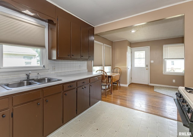 1035 14th Ave S, Clinton, IA 52732 - kitchen featuring black gas stove, light countertops, light wood-style flooring, and ornamental molding