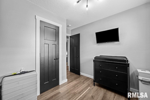 3307 Clover Hills Dr, Bettendorf, IA 52722 - bedroom with wood finished floors and a textured ceiling