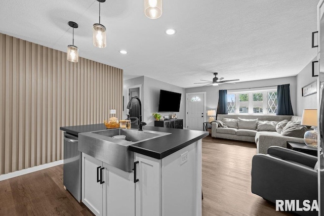 3307 Clover Hills Dr, Bettendorf, IA 52722 - kitchen featuring dark countertops, stainless steel dishwasher, ceiling fan, white cabinets, and open floor plan