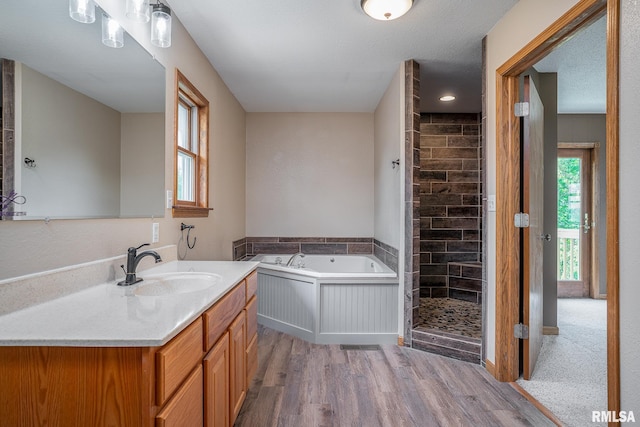 4460 160th St, Clinton, IA 52732 - full bathroom with a bath, a shower stall, vanity, and wood finished floors