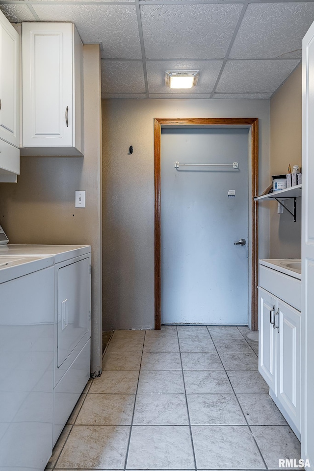 4460 160th St, Clinton, IA 52732 - washroom featuring cabinet space, washing machine and dryer, and light tile patterned floors