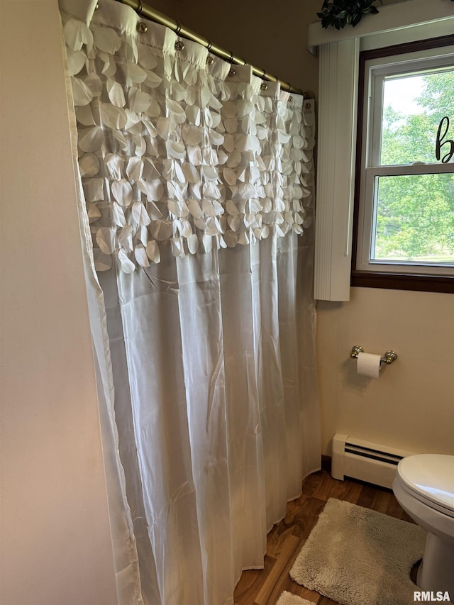 101 E 6th St, Sherrard, IL 61281 - bathroom featuring a baseboard radiator, wood finished floors, and a shower with curtain