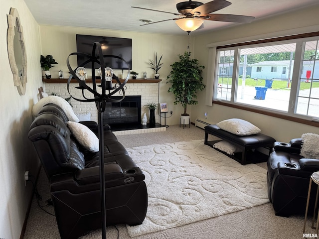 101 E 6th St, Sherrard, IL 61281 - carpeted living room featuring a baseboard heating unit, a fireplace, and a ceiling fan