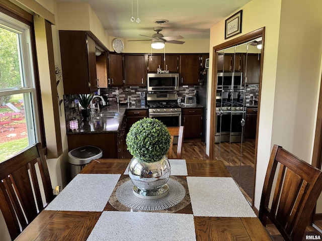 101 E 6th St, Sherrard, IL 61281 - kitchen featuring appliances with stainless steel finishes, backsplash, dark brown cabinetry, ceiling fan, and dark countertops