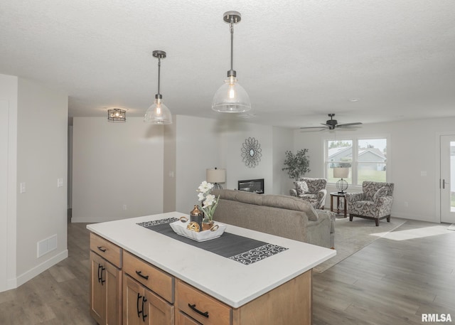 624 Rock Point Rd, Colona, IL 61241 - kitchen featuring light countertops, light wood-style flooring, pendant lighting, a center island, and a textured ceiling