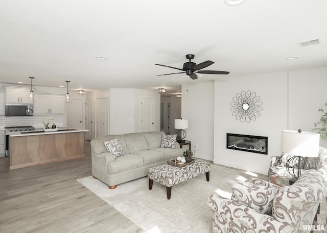 624 Rock Point Rd, Colona, IL 61241 - living area with a glass covered fireplace, light wood-style flooring, a ceiling fan, and recessed lighting