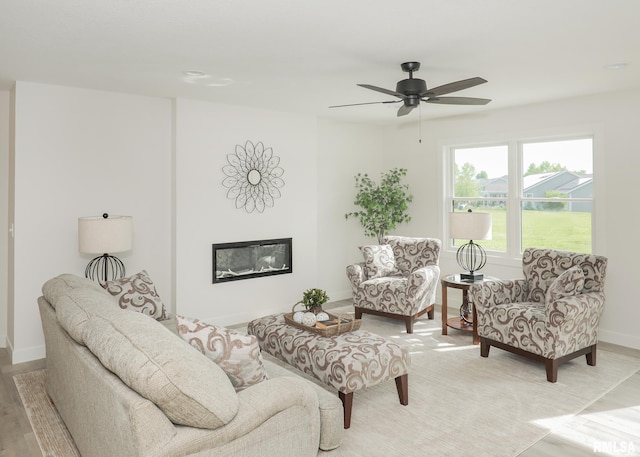 624 Rock Point Rd, Colona, IL 61241 - living room featuring light wood finished floors, a ceiling fan, and a glass covered fireplace