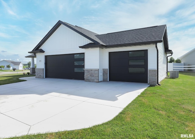 624 Rock Point Rd, Colona, IL 61241 - view of front of home with stone siding, a front lawn, a shingled roof, and concrete driveway
