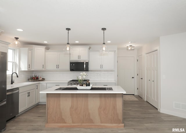 624 Rock Point Rd, Colona, IL 61241 - kitchen featuring stainless steel appliances, light countertops, a center island, light wood-style flooring, and recessed lighting