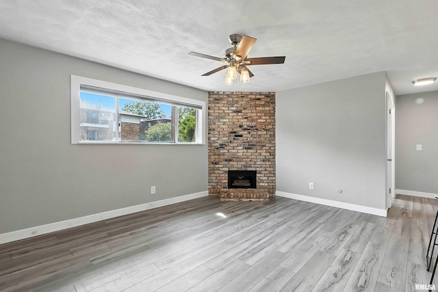 3045 4th St Unit 1, Moline, IL 61265 - unfurnished living room featuring wood finished floors, ceiling fan, and a brick fireplace