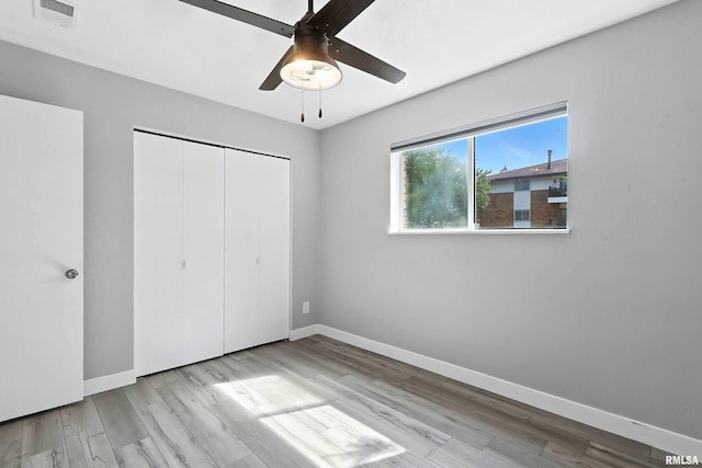 3045 4th St Unit 1, Moline, IL 61265 - unfurnished bedroom featuring wood finished floors, a closet, and a ceiling fan