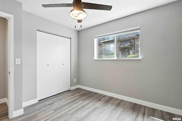 3045 4th St Unit 1, Moline, IL 61265 - unfurnished bedroom featuring wood finished floors, a closet, and a ceiling fan