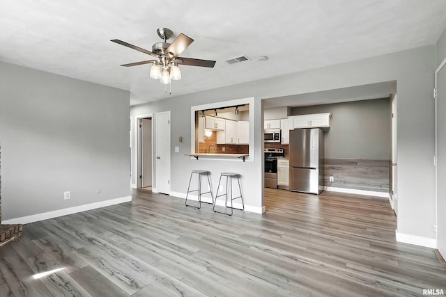 3045 4th St Unit 1, Moline, IL 61265 - unfurnished living room with ceiling fan and light wood-type flooring