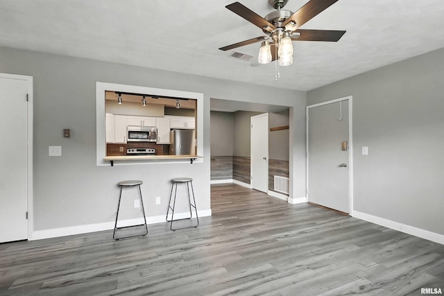 3045 4th St Unit 1, Moline, IL 61265 - unfurnished living room featuring a ceiling fan, wood finished floors, and rail lighting