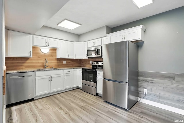 3045 4th St Unit 1, Moline, IL 61265 - kitchen with stainless steel appliances, white cabinets, light wood-style flooring, and light stone countertops