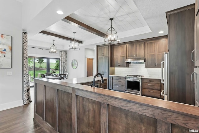 6250 Whispering Hill Ct, Bettendorf, IA 52722 - kitchen featuring appliances with stainless steel finishes, under cabinet range hood, backsplash, dark wood-style flooring, and a chandelier