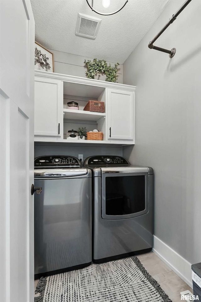 6250 Whispering Hill Ct, Bettendorf, IA 52722 - laundry room featuring cabinet space, washer and clothes dryer, and a textured ceiling