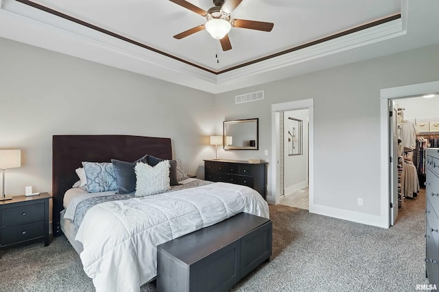 6250 Whispering Hill Ct, Bettendorf, IA 52722 - bedroom with carpet flooring, a tray ceiling, ornamental molding, a spacious closet, and a ceiling fan