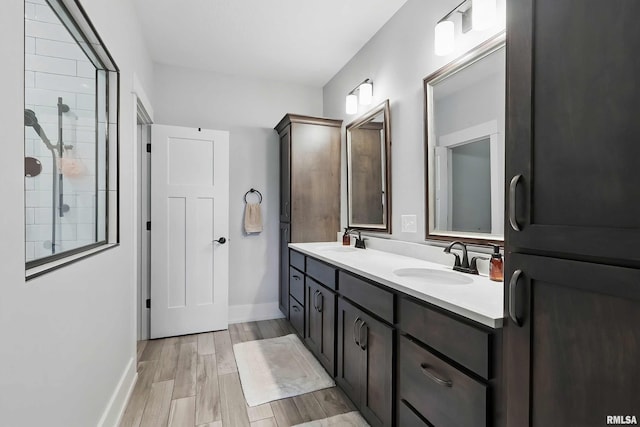 6250 Whispering Hill Ct, Bettendorf, IA 52722 - full bath featuring double vanity, a tile shower, and wood finished floors