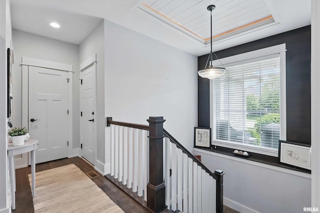6250 Whispering Hill Ct, Bettendorf, IA 52722 - hallway with an upstairs landing, dark wood-style flooring, a raised ceiling, and recessed lighting