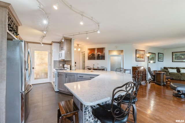 1800 7th St Unit 7A, East Moline, IL 61244 - kitchen featuring white appliances, a peninsula, a breakfast bar, open floor plan, and ornamental molding