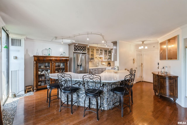 1800 7th St Unit 7A, East Moline, IL 61244 - kitchen with stainless steel fridge, a breakfast bar, dark wood-style flooring, glass insert cabinets, and decorative backsplash