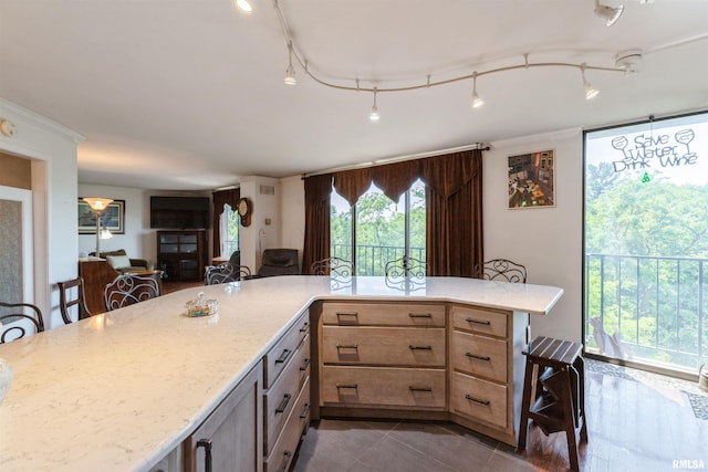 1800 7th St Unit 7A, East Moline, IL 61244 - kitchen featuring light brown cabinets, light stone countertops, a kitchen bar, open floor plan, and dark tile patterned flooring