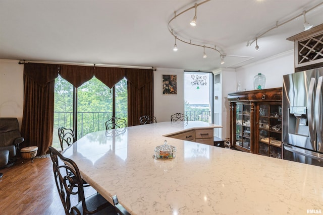 1800 7th St Unit 7A, East Moline, IL 61244 - kitchen featuring stainless steel refrigerator with ice dispenser, ornamental molding, track lighting, wood finished floors, and light stone counters