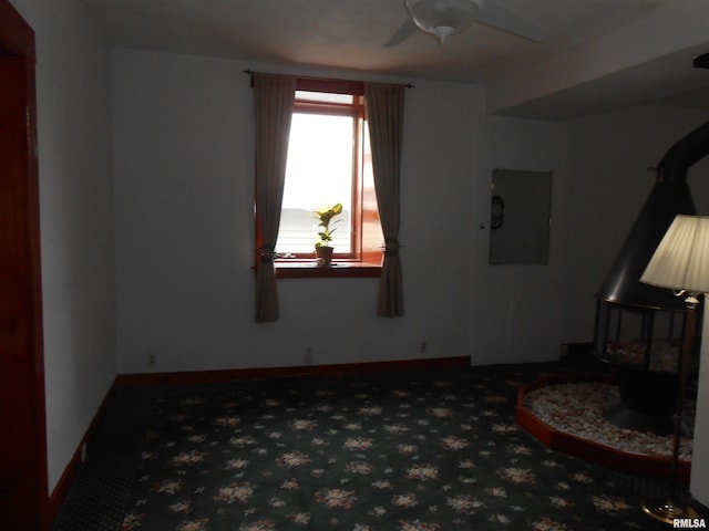 636 3rd St, Buffalo, IA 52728 - living room with a ceiling fan, electric panel, carpet floors, and a wood stove