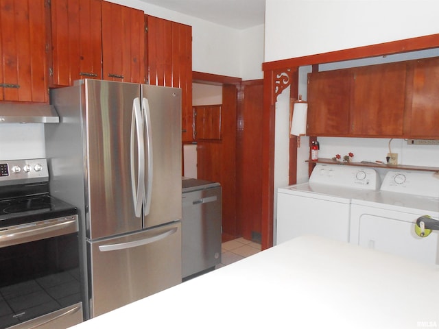 636 3rd St, Buffalo, IA 52728 - kitchen with appliances with stainless steel finishes, wall chimney exhaust hood, washing machine and clothes dryer, light countertops, and brown cabinets