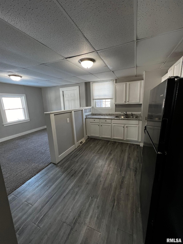 201 N 20th St, East Moline, IL 61244 - kitchen featuring freestanding refrigerator, white cabinets, a paneled ceiling, a peninsula, and dark wood-style flooring