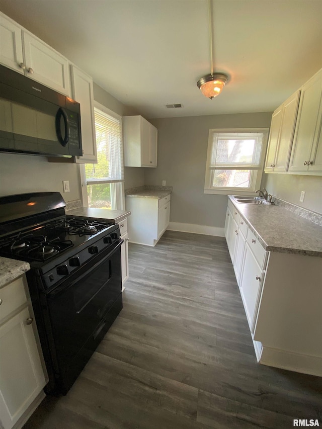201 N 20th St, East Moline, IL 61244 - kitchen with black appliances, dark wood-style flooring, and white cabinetry