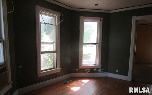 504 N College Ave, Aledo, IL 61231 - empty room featuring wood finished floors, plenty of natural light, and ornamental molding