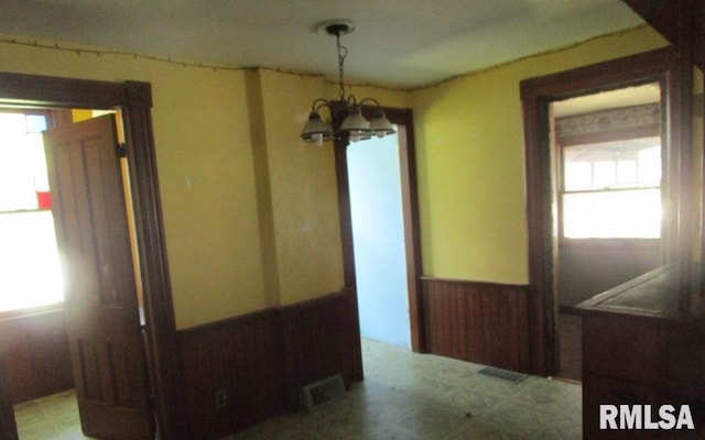 504 N College Ave, Aledo, IL 61231 - unfurnished dining area featuring a wainscoted wall and a chandelier