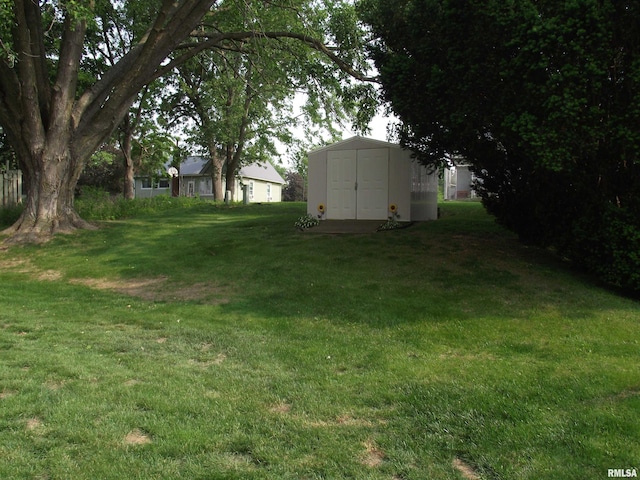 619 E 6th St, Tipton, IA 52772 - view of green lawn featuring a storage shed
