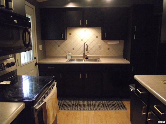 619 E 6th St, Tipton, IA 52772 - kitchen with stainless steel electric range oven, black microwave, light countertops, and light wood-type flooring