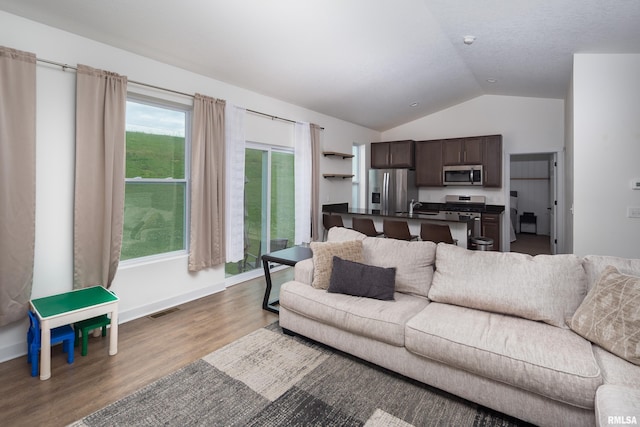 3458 Glenbrook Cir N, Bettendorf, IA 52722 - living area with vaulted ceiling, wood finished floors, and healthy amount of natural light