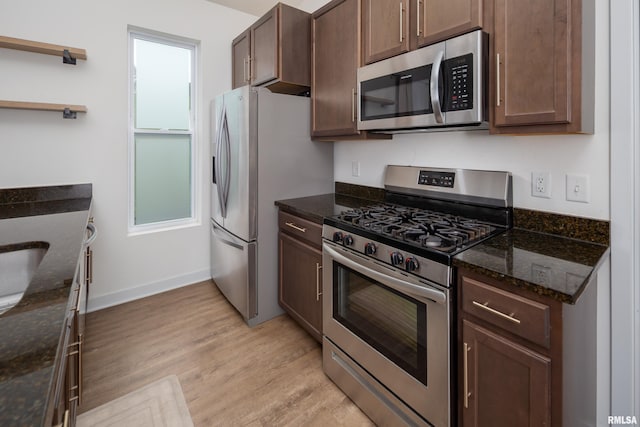 3458 Glenbrook Cir N, Bettendorf, IA 52722 - kitchen featuring stainless steel appliances, light wood finished floors, dark stone countertops, dark brown cabinets, and open shelves