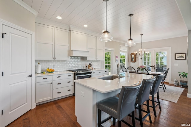 3563 Cobblestone Dr, Bettendorf, IA 52722 - kitchen with a kitchen breakfast bar, light countertops, decorative backsplash, white cabinetry, and ornamental molding