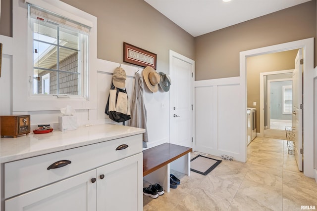 3563 Cobblestone Dr, Bettendorf, IA 52722 - mudroom with light marble finish flooring, a decorative wall, washing machine and clothes dryer, and wainscoting