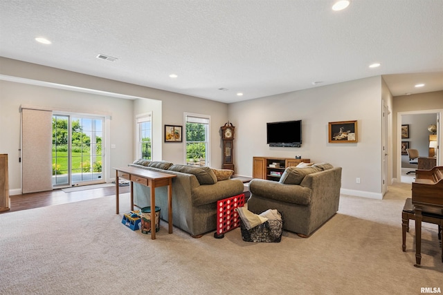 3563 Cobblestone Dr, Bettendorf, IA 52722 - living room with light colored carpet, recessed lighting, healthy amount of natural light, and a textured ceiling
