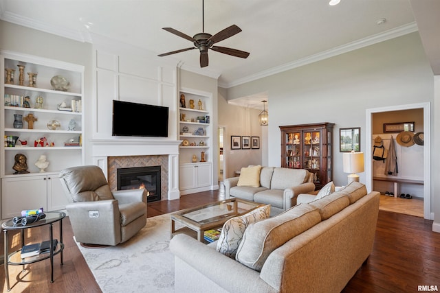 3563 Cobblestone Dr, Bettendorf, IA 52722 - living room with ornamental molding, ceiling fan, dark wood-type flooring, a tile fireplace, and built in features