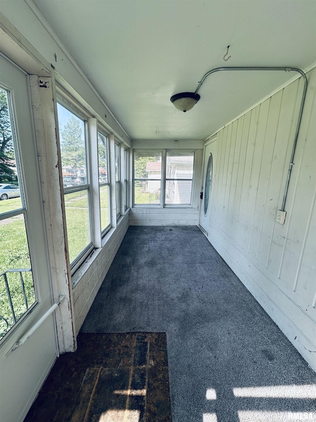 239 15th Ave, East Moline, IL 61244 - unfurnished sunroom with plenty of natural light, carpet flooring, and wood walls