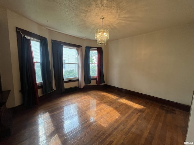 421 W 17th St, Davenport, IA 52803 - unfurnished room with a chandelier, dark wood-style floors, and a textured ceiling