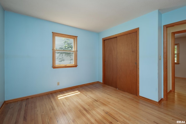 3403 Kimberly Downs Rd, Davenport, IA 52807 - unfurnished bedroom featuring light wood-style floors, a closet, and multiple windows
