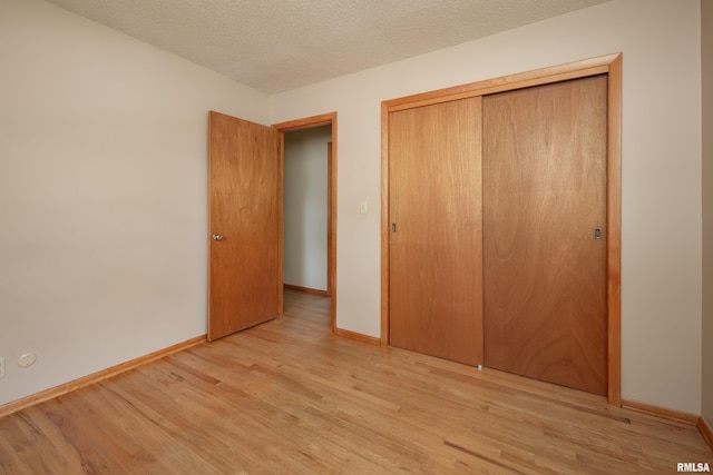 3403 Kimberly Downs Rd, Davenport, IA 52807 - unfurnished bedroom with light wood-style floors, a closet, and a textured ceiling